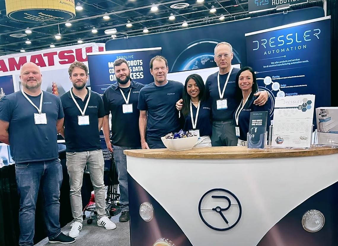 Dressler Automation's team stands in front of their booth at Automate 2022.
